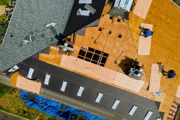 a-roofer-nailing-shingles-with-air-gun-replacing-roof-cover-protection-being-applied